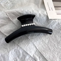 Dettaglio di una grande pinza per capelli nera con eleganti decorazioni in perle bianche - Nero