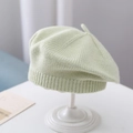 Light green knitted baby beret hat with top stem detail on a clean white display stand - Plain Knit Beret / Pale Green