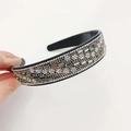 Sparkling black headband with multicolor rhinestones held against a white background - Grey Crystal Transparent Grey