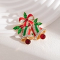 Détail macro d'une broche cloche de Noël avec nœud rouge et strass brillants - Cloche de Noël