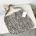 Detail shot of leopard print canvas tote bag with wide strap on a white minimal desk - Regular Leopard Beige
