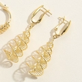 Macro shot of gold double-spiral geometric earrings with DNA-inspired modern metal texture - DNA Spiral Long Drop Style