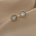 Macro shot of French luxury pearl earrings with gold twisted edge and grey textured center - Vintage Gold Grey Texture