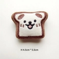 Close-up of a cartoon toast plush brooch with cute dog embroidery measuring 4.5cm by 5.5cm - Bread Slice