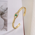 Detailopname van gouden evil eye armband met groene steen en tarwe-aar textuur - Goud (31291)