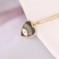 Detail of golden heart pendant with black enamel inlay and evil eye motif on a fine chain - Black