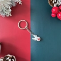 Christmas reindeer keychain with red nose on festive red and green background - Reindeer