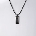 Détail macro du pendentif rectangulaire en fibre de carbone sur chaîne en acier noir - Collier Noir + Pendentif Noir