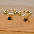 Detail of gold huggie earrings with round black zircon pendants and three-prong setting - Gold Black Zircon