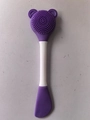 Purple silicone dual-ended facial brush with massage nubs and a white handle - Purple Spatula Head