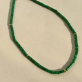 Close-up of green malachite textured beads and gold disc spacers on beaded necklace - Malachite
