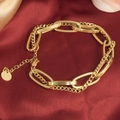 Elegante bracciale a doppia catena dorata con ciondolo tondo su seta rossa - Oro