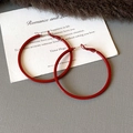Close-up of vibrant red round oversized hoop earrings with smooth lacquered finish - Style 63 / Diameter 50mm / Red