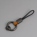 Porte-clés en cuir marron avec anneau en métal gris foncé et cordon tressé noir - Orange + Gunmetal