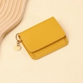 Dettaglio del portafoglio in pelle martellata gialla con elegante ciondolo in metallo oro - Giallo