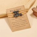 Three-piece set of black onyx woven bracelets displayed on an informative kraft paper card - Black Agate