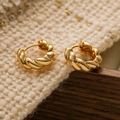 Dettaglio di orecchini a cerchio intrecciati placcati oro su maglia e base in legno - Trama Intrecciata / Oro