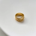 Nahaufnahme eines mehrlagigen goldenen gedrehten Seilrings auf minimalistischer Basis - US 8 / Gold Gedreht Drelagig