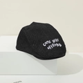 Detailansicht der schwarzen Denim-Baby-Baskenmütze mit weißer 'COME HERE' Bestickung - 48-52cm (1-3 Jahre) / Schwarz