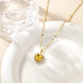 Close-up of yellow heart-shaped pendant with halo stones on a golden necklace chain - Yellow Pendant Necklace
