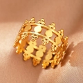 Macro shot of gold hollow crown ring with geometric circles on champagne satin silk - Gold Crown Ball (C1475)