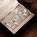 Polished silver bow earrings in a premium jewelry box with elegant fabric background - Silver Bowknot