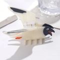 Detailed close-up of a bird-shaped acetate hair claw clip with black and red accents - Petrel