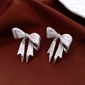 Dettaglio degli orecchini a fiocco argento su velluto rosso scuro e metallo - Ago d'argento-Argento-Fiocco / Argento