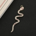 Dettaglio di un ciondolo a serpente in oro 18 carati con cristalli bianchi e rossi - Oro