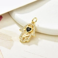 Macro shot of gold Hamsa hand pendant with black heart stone on ceramic tray - Black Zirconia