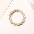 Detail of a beige elastic hair tie featuring a knotted texture and plastic fastener - Braided Twist - Plastic Buckle / Off-white