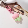Close-up of pink and green cartoon cloud keychain with pink metal ring on white surface - Pink Green Cloud
