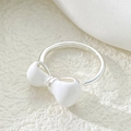 Close-up of adjustable silver ring featuring a white enamel bow on silk background - White Enamel Bow Ring (N-429) / White