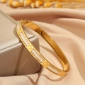 Elegante brazalete de titanio dorado con circonitas rectangulares y tréboles - Brazalete de Trébol Dorado con Pedrería