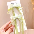 Fermagli a fiocco verde chiaro per bambine con nastro e dettagli in tulle su carta - Verde 2 Pezzi