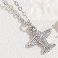 Macro shot of silver airplane pendant necklace with sparkling cubic zirconia pavé details - Silver Airplane
