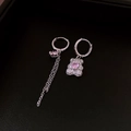 Dettaglio orecchini orsetto argento con pietre cuore rosa e catena nappa su sfondo nero - Orecchino-Argento-Rosa-Asimmetrico