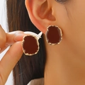 Macro shot of irregular gold-edged earrings with deep red enamel finish on model - KC Gold Brown (05 KC Gold Brown 8816)