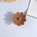 Detalle de una pinza para el cabello mate marrón con forma de flor sobre fondo blanco - Café Oscuro Mate