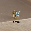 Macro detail of 6mm golden butterfly cartilage hoop with blue and clear zircon stones - 6mm / Gold-Blue