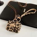Gros plan du mini sac à motif léopard avec fermoirs dorés sur fond en cuir noir - Collier Mini Sac Imprimé Léopard / Gris