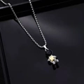 Macro shot of silver astronaut pendant holding a gold star on a box chain necklace - A02 Holding Star