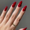 Glossy red long almond shape press-on nails shown with a golden ring detail - Almond Shape / Glossy Red