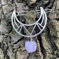 Close-up of hollow moon hair clip with purple crystal stone on natural bark background - Amethyst