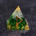 Green crystal Orgone pyramid with gold foil and Fehu rune symbol on dark surface - Joy - Continuous Good Luck