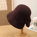 Detalle de un sombrero cloche de lana marrón con un lazo elegante sobre soporte de madera - M(56-58cm) / Marrón