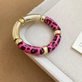 Detalle de pulsera con cuentas acrílicas de leopardo rosa y tubos metálicos dorados - Leopardo Rosa