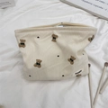 Detailed texture of corduroy makeup bag with cute bear embroidery and heart pattern - Off-white