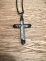 Vue détaillée du pendentif croix noir et argent de style punk sur une chaîne sombre - Incrustation d'acier inoxydable couleur acier