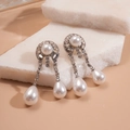 Elegante Silberohrringe mit geometrischen Perlen und Diamanten auf weißem Stein - Silber